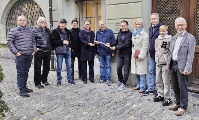 Gruppe von Mitgliedern der Fédération Suisse Motonautique (FSM) posiert vor historischem Gebäude.