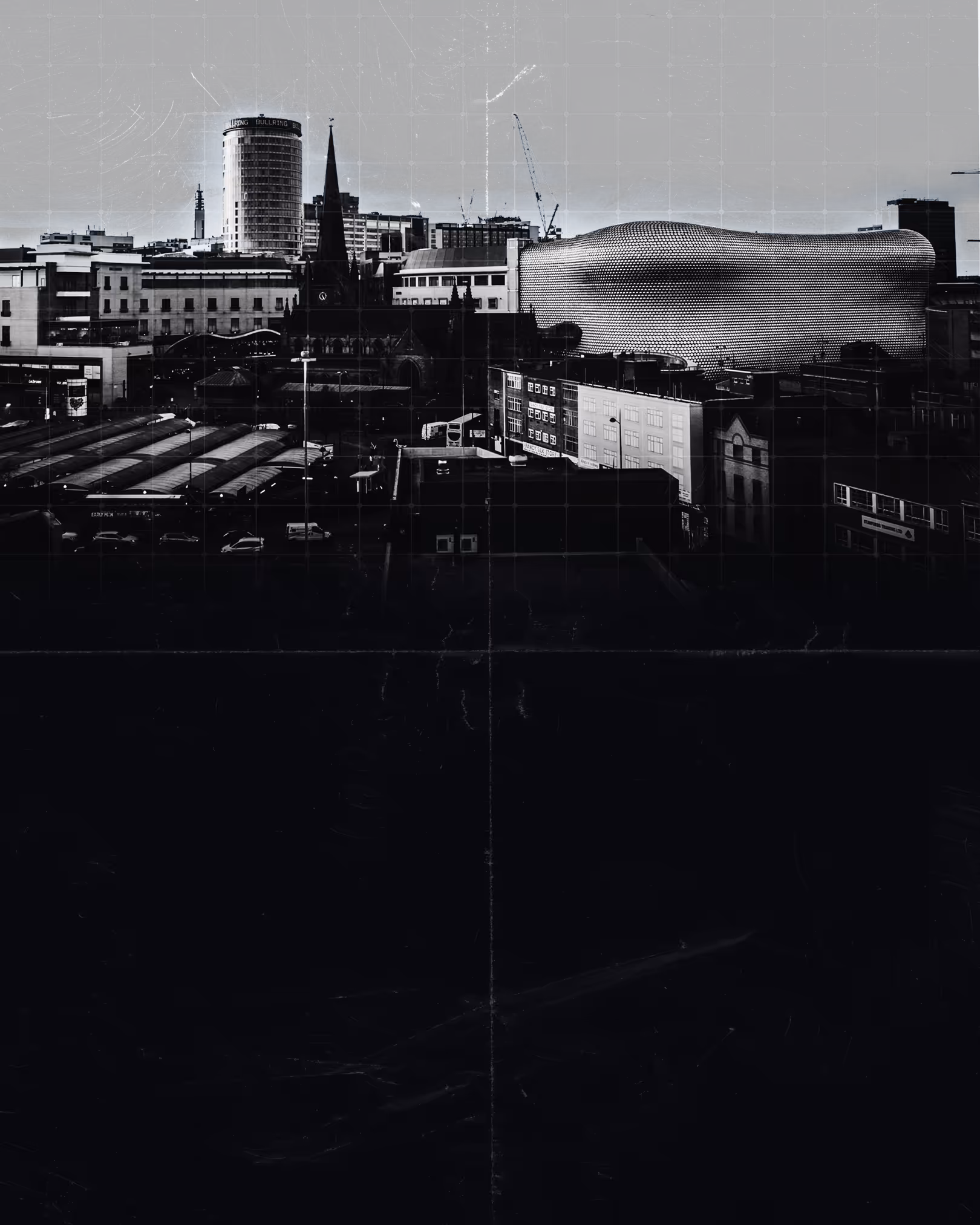 Black and white cityscape featuring the cylindrical Bullring building and the modern, curved Selfridges building in Birmingham.