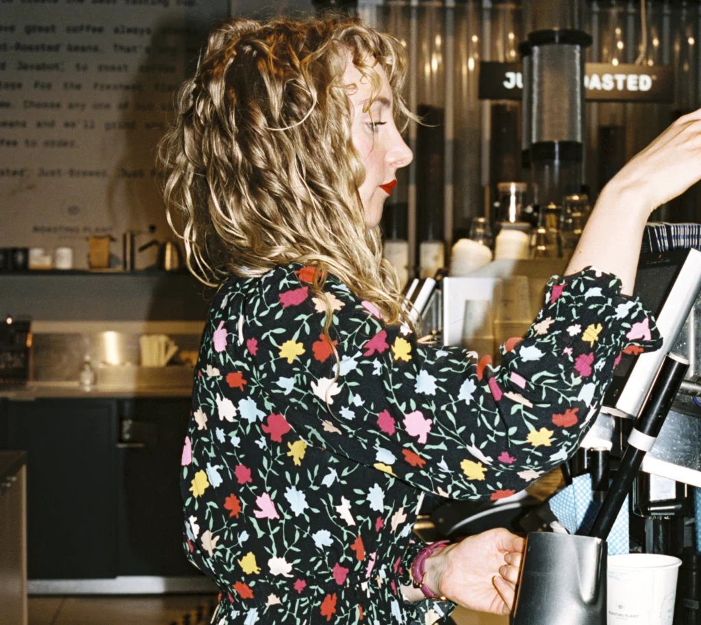 A barista making coffee for a customer