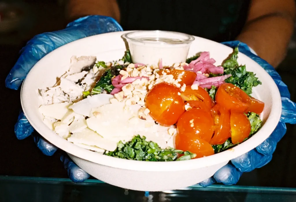 Someone holding a fresh salad bowl