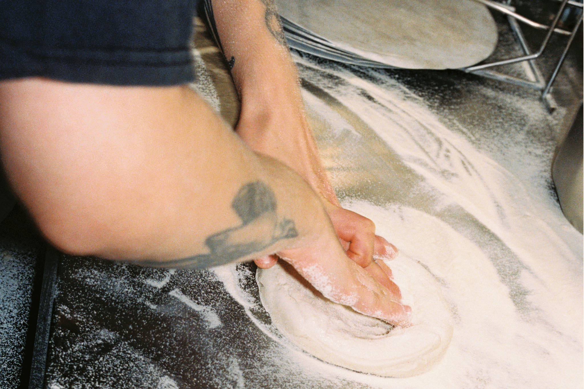 Chef rolling pizza dough on a counter