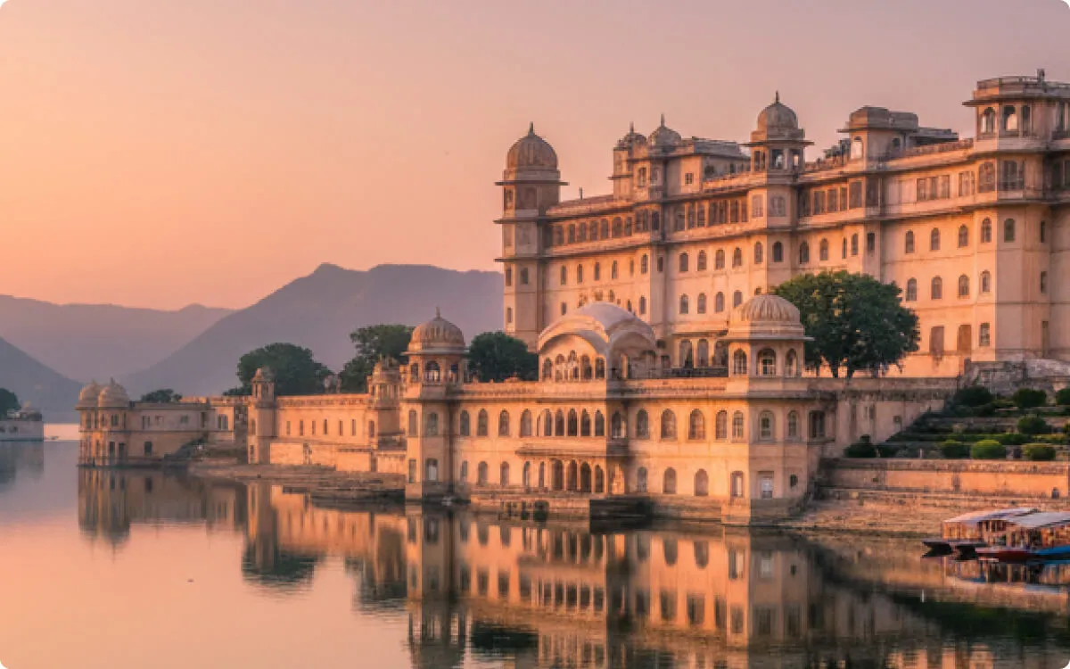 Sandstone palace beside a lake at sunset