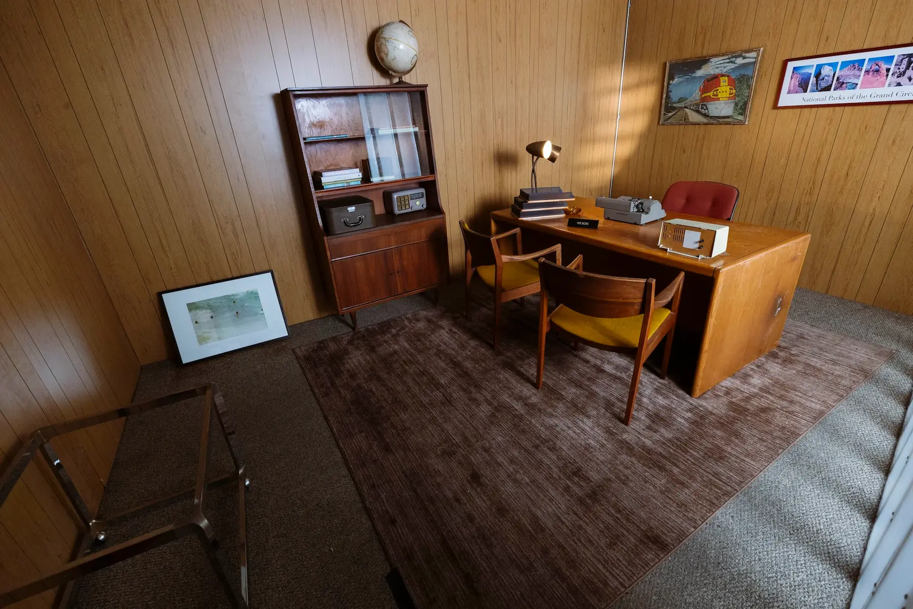 Cozy workspace set with mid-century modern desk and wood paneling at STMNT Studios