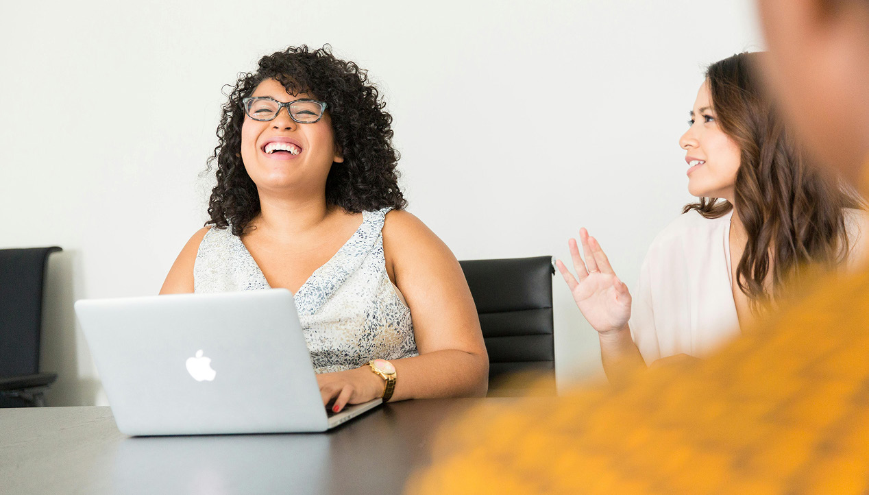 Two nonprofit colleagues celebrating a decision at a laptop.