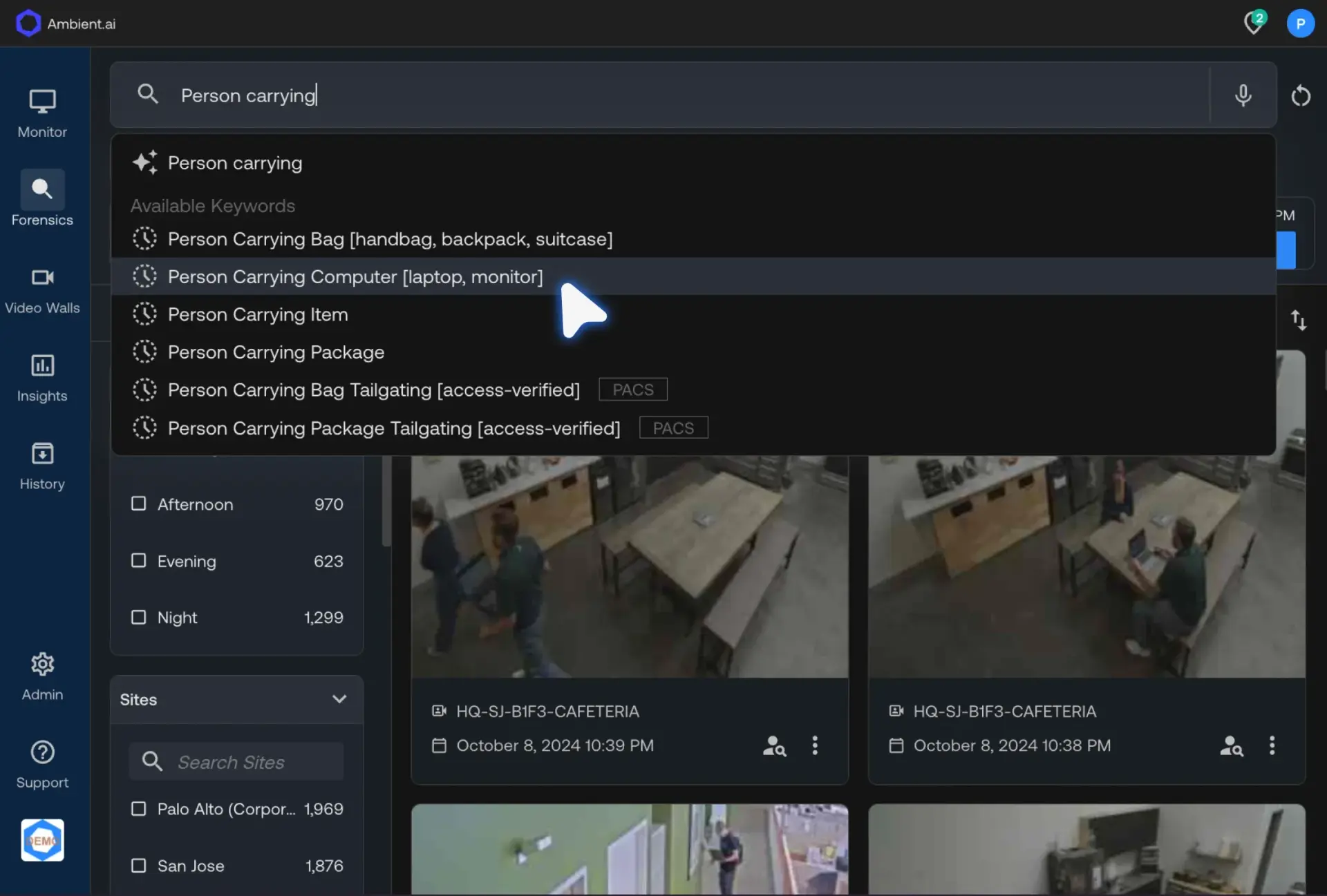 Ambient.ai interface showing a search bar with 'Person carrying' typed and dropdown options like Person Carrying Bag and Person Carrying Computer.