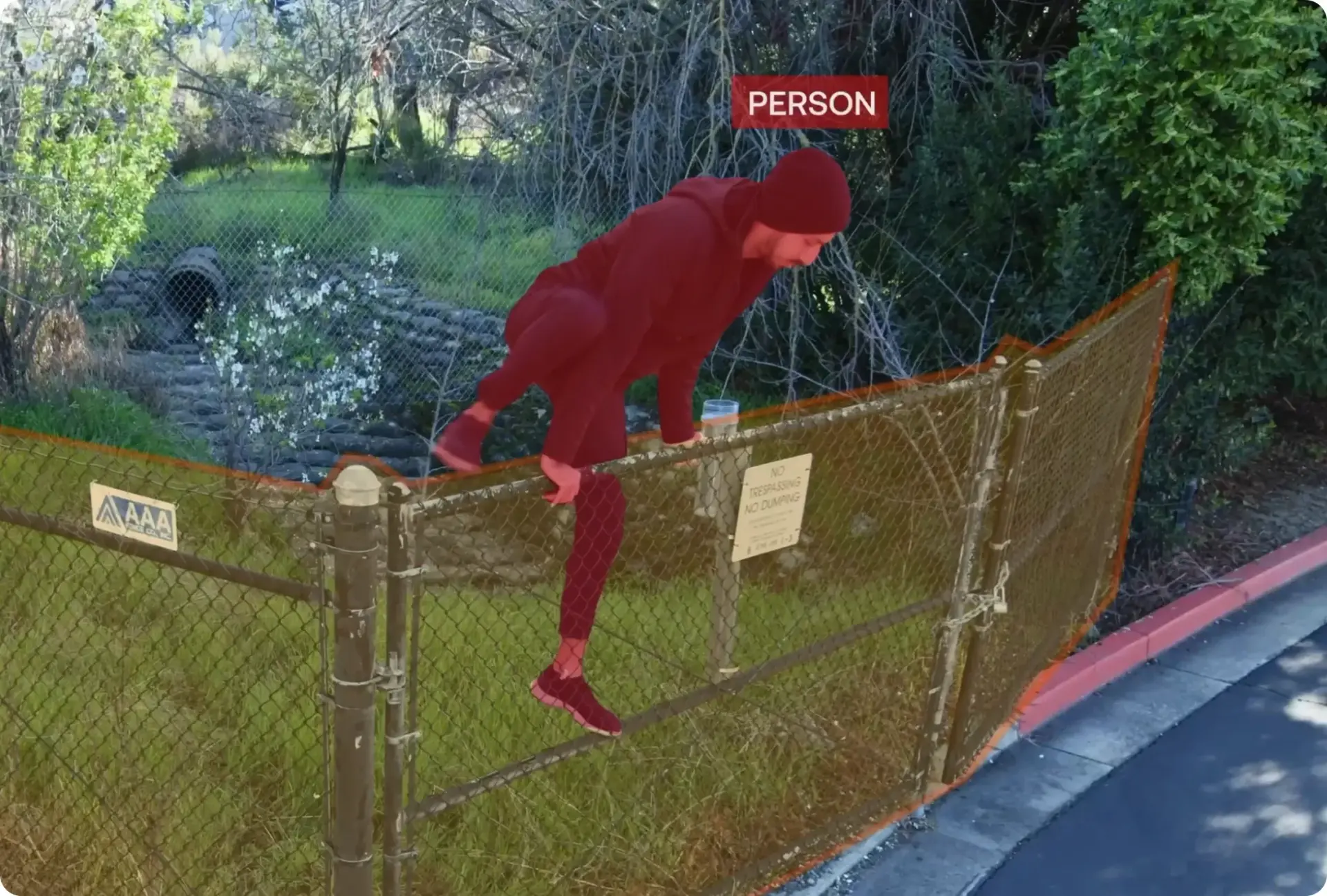 A man climbing over a fence. The fence and the man are highlighted and labelled.