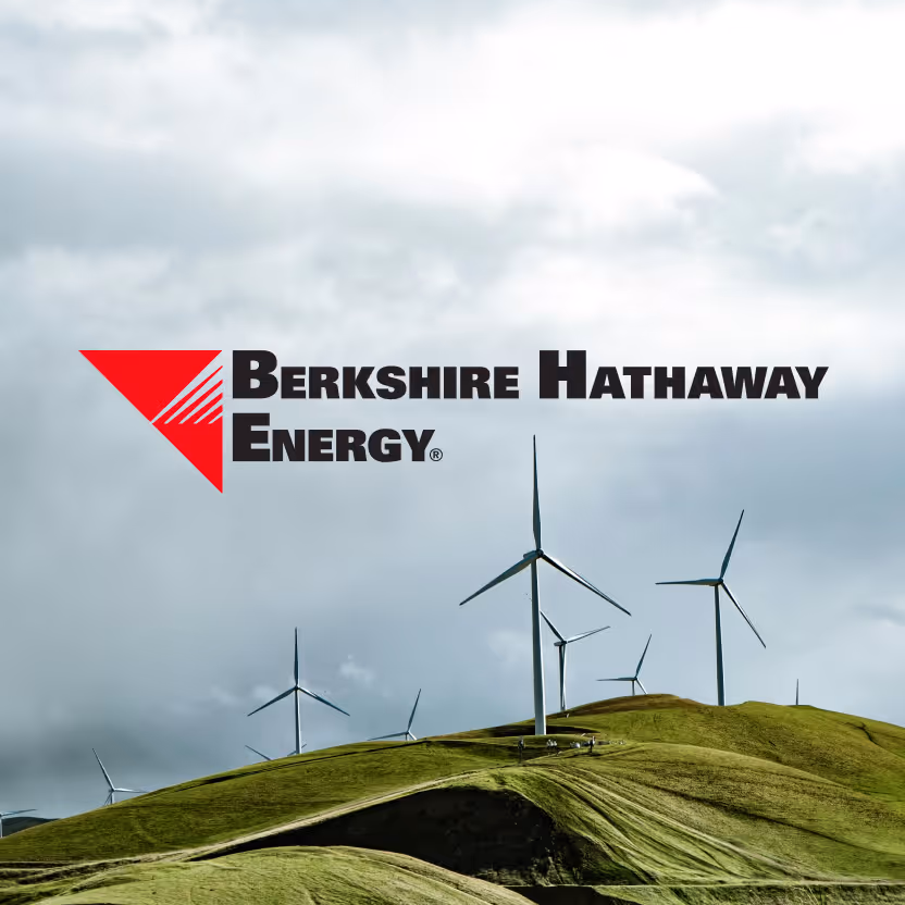 Wind turbines on green rolling hills under a cloudy sky with the Berkshire Hathaway Energy logo overlay.