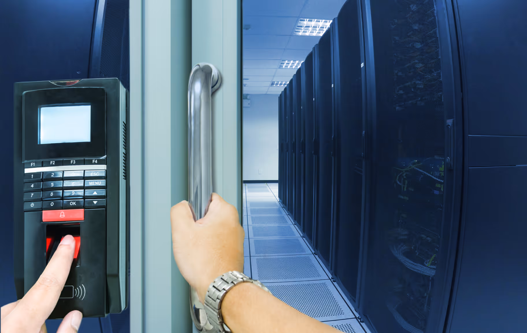 Person using a fingerprint scanner to gain access to a data center with rows of server racks.