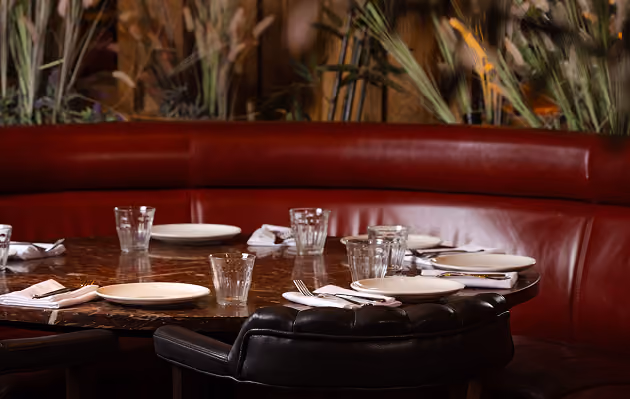 Red banquette seating and set tables at Mama Yo