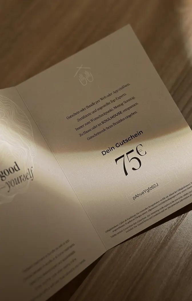 Ein 75-Euro-Gutschein von Soulhouse in einer offenen beigefarbenen Karte, platziert auf einer Holzoberfläche mit Licht- und Schatteneffekten.