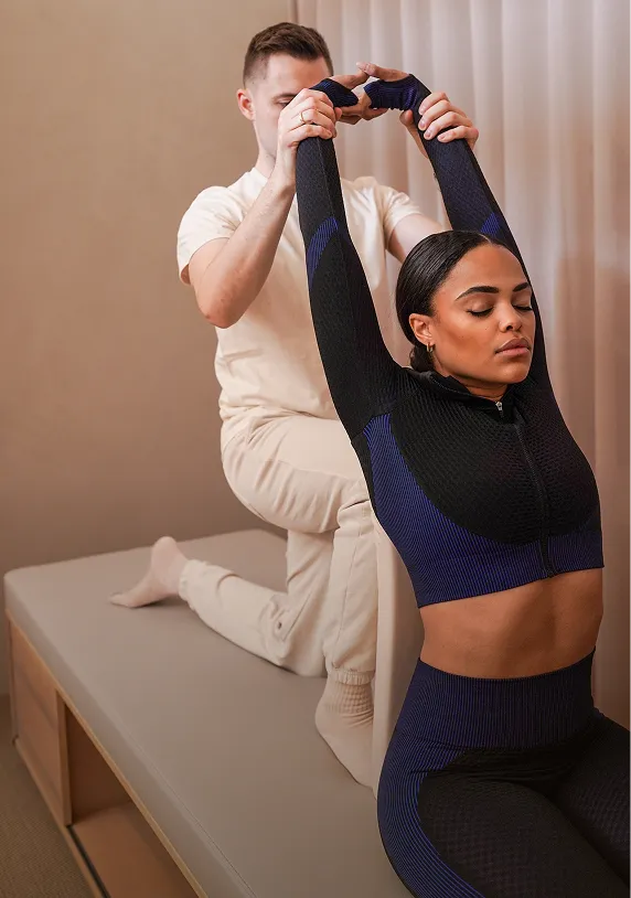 Eine Frau in Sportbekleidung bekommt eine Assisted Stretch Session.