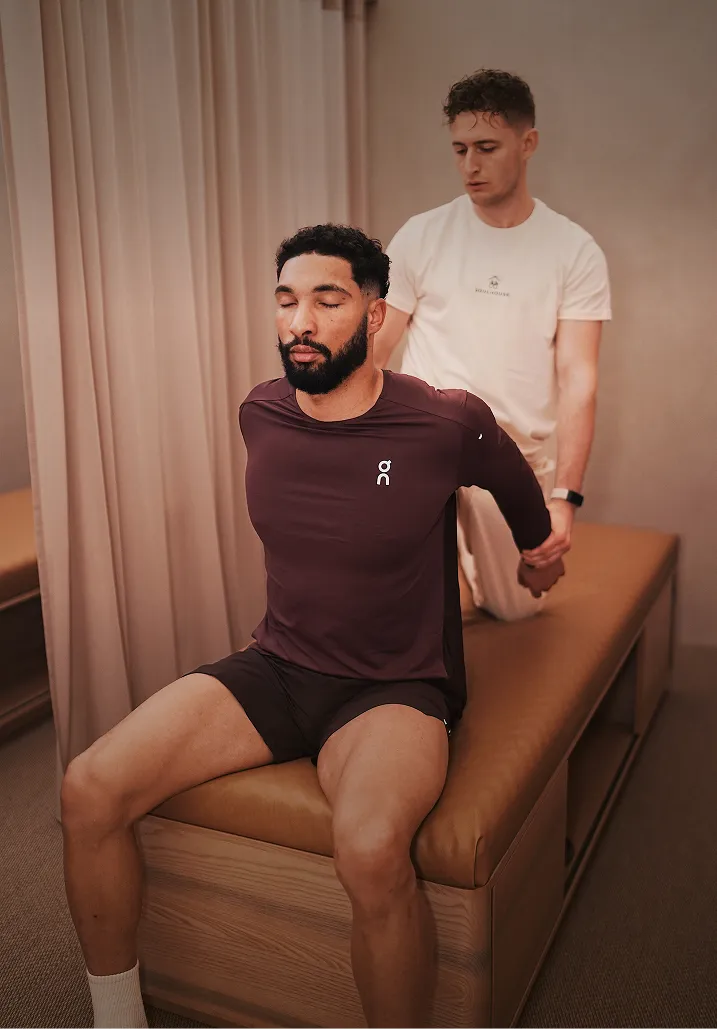 Ein Mann mit geschlossenen Augen bekommt eine Assisted Stretch Session.