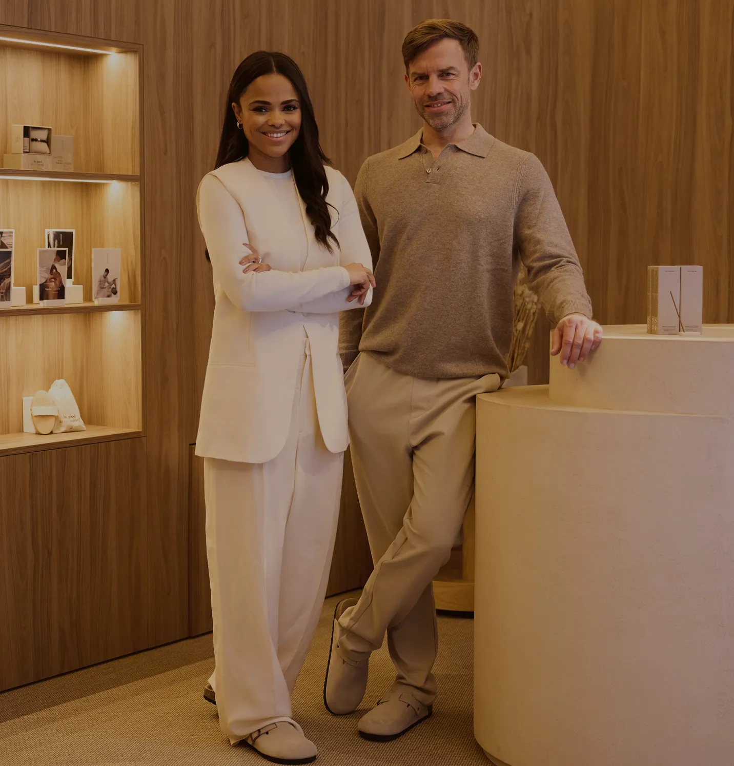 Gruppenfoto der Soulhouse Geschäftsführung, eine Frau in weißem Outfit und ein Mann in beigem Pullover und Hose, stehen in einem modernen Raum mit Holzverkleidung.