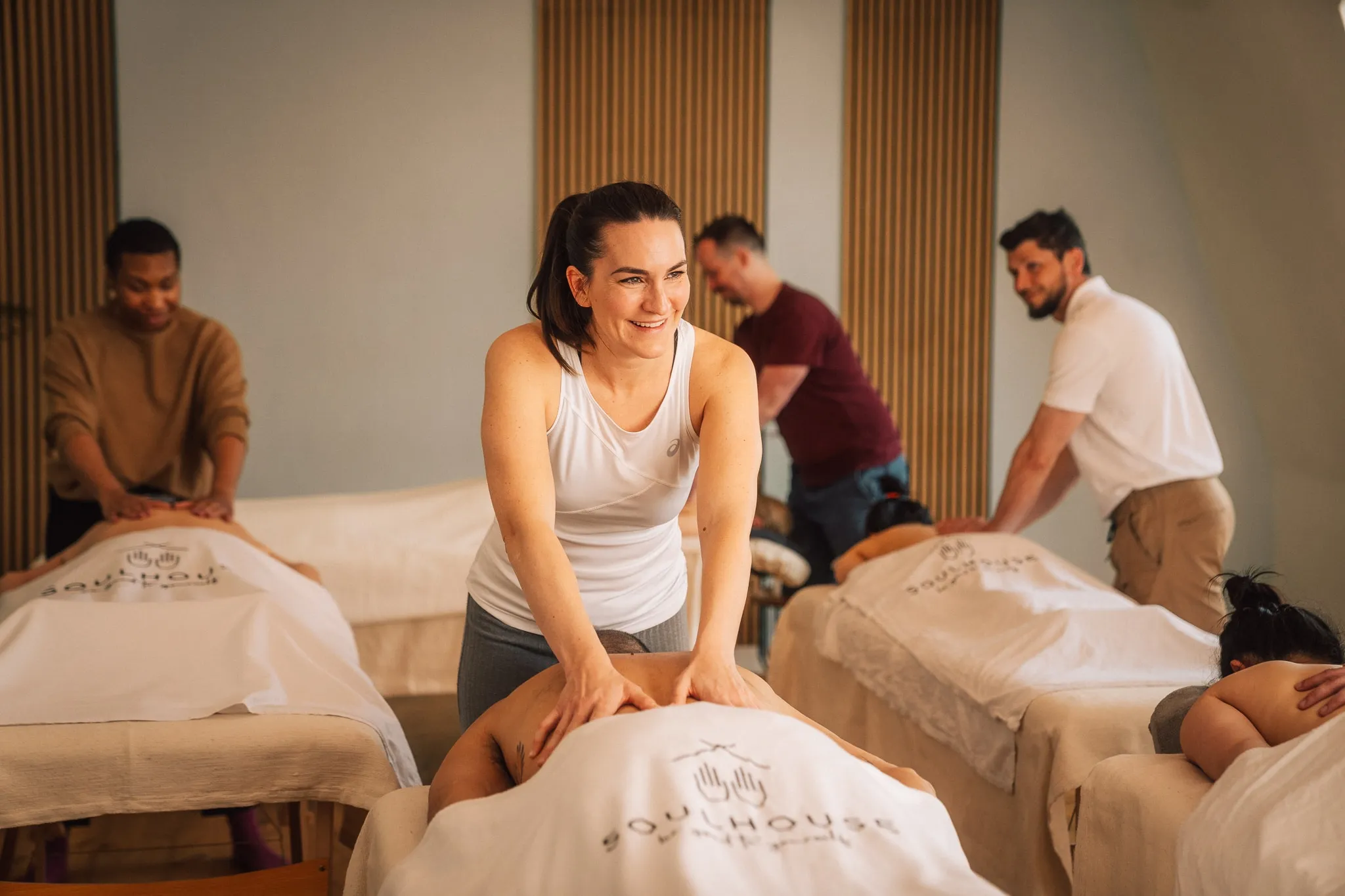 Eine Frau lernt eine Massage in der Soulhouse Academy. Eine Massage Lehrer erklärt seinen Studenten wie die Massage abläuft und funktioniert.