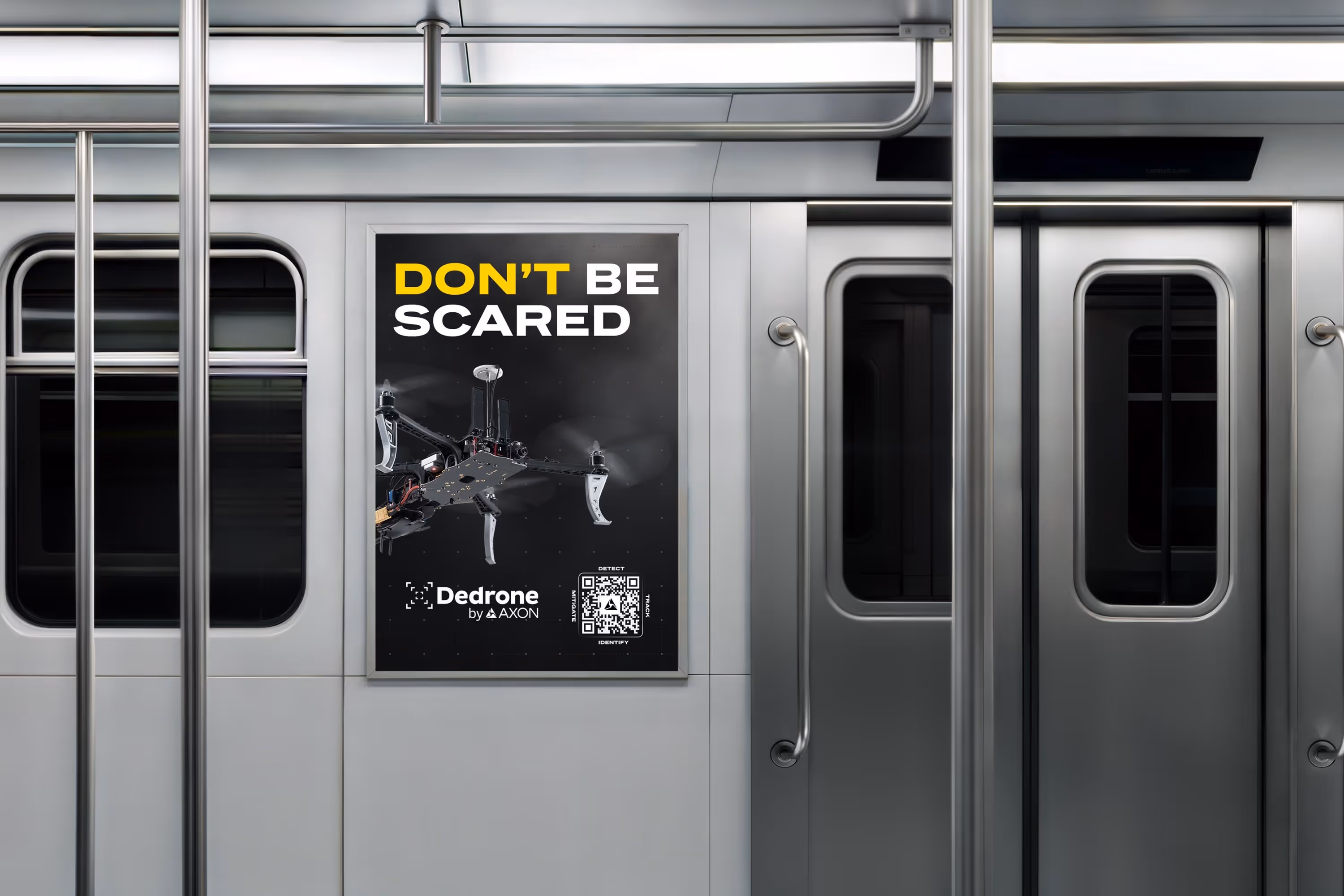 Subway car interior with a poster showing a drone and text reading 'DON'T BE SCARED' and 'Dedrone by Axon'.