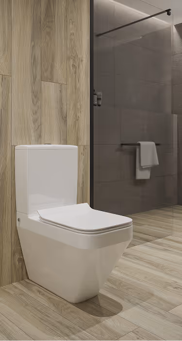 Modern white toilet installed against a wooden wall with a glass shower area and towel rack in the background.
