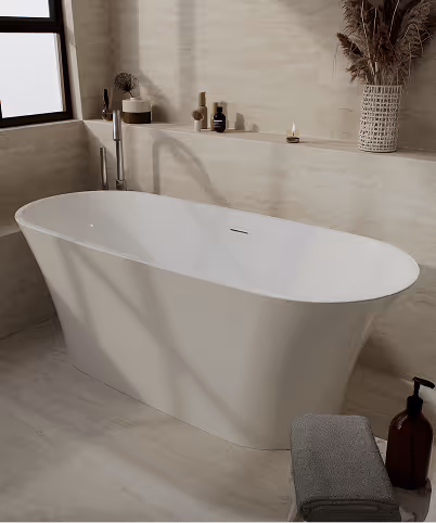 Modern freestanding white bathtub in a beige-toned bathroom with window, decorative items, and towels.