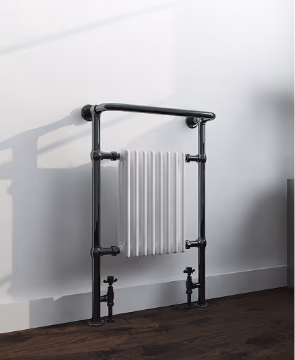Modern white radiator mounted on black metal pipes against a white wall with wooden floor.