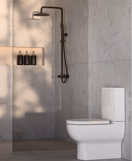 Modern bathroom with a white toilet and a black rain showerhead mounted on a marble wall, featuring three black soap dispensers in a recessed niche.