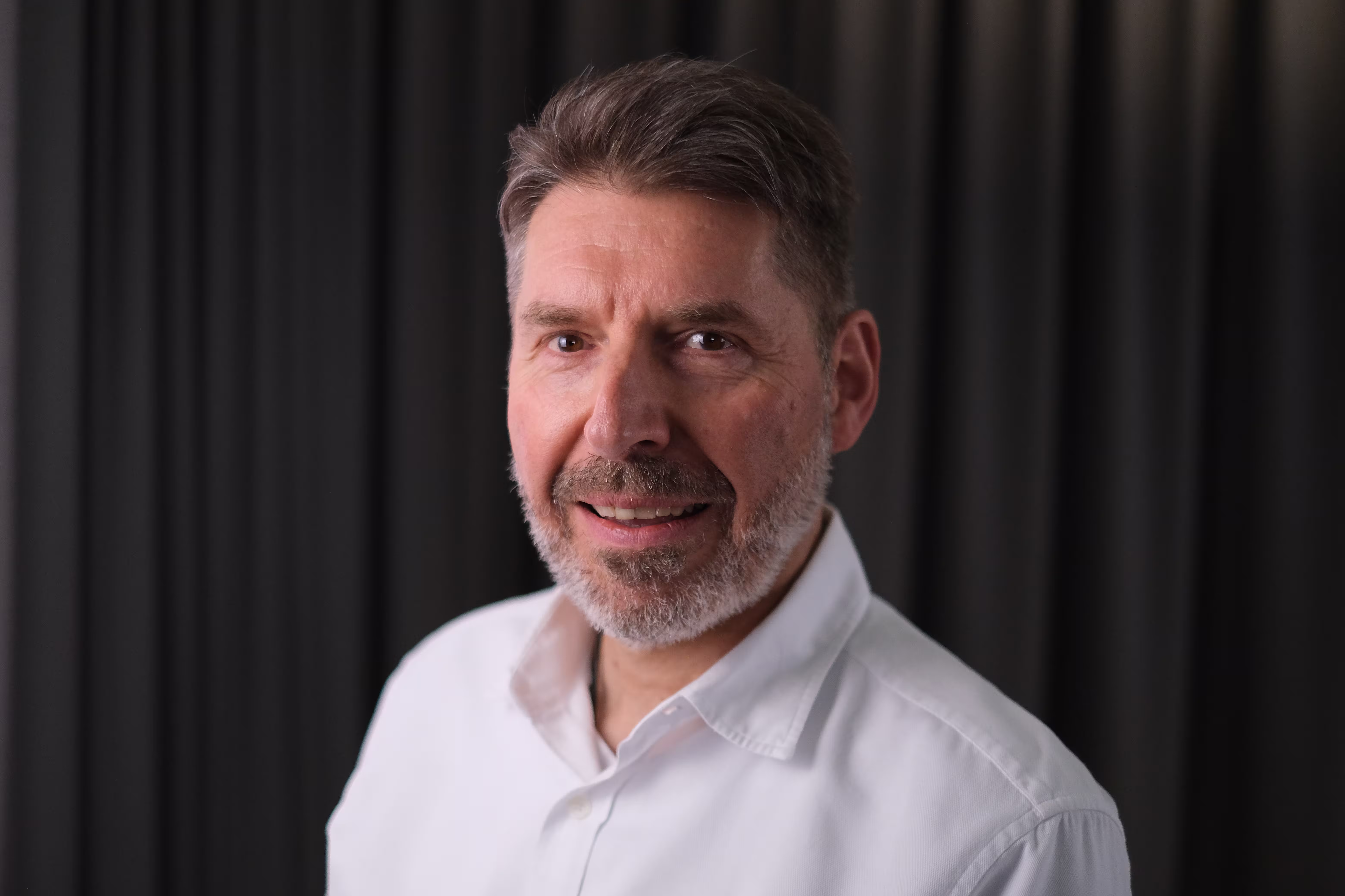 Portrait of a bearded man against a dark background