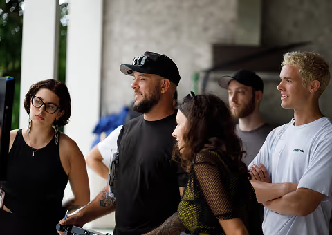 Video production crew collaborating on set during a mobile video ad shoot