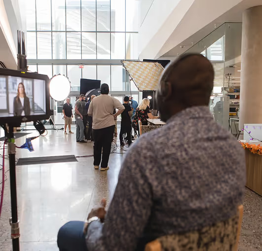 Corporate video production shoot with crew and lighting setup.