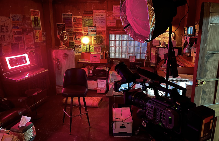 Professional video production camera and lighting setup inside a styled indoor shoot location