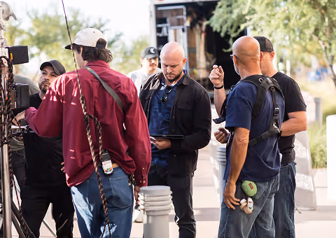 Video production crew reviewing footage on a tablet during an on-location commercial shoot