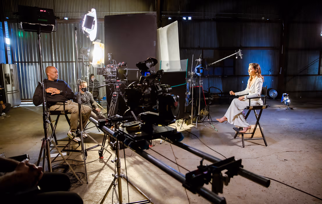 Corporate video production interview setup with professional camera rig and talent seated on set