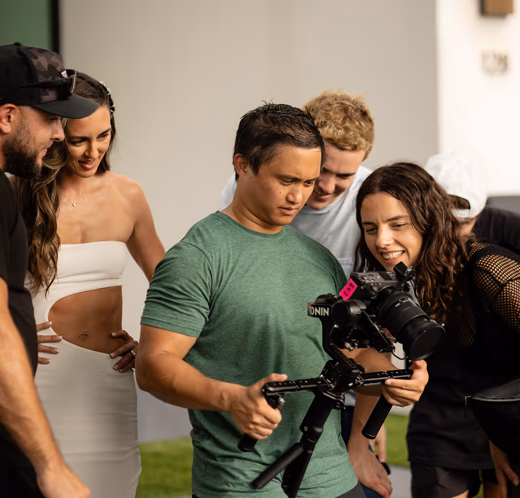 Crew planning video shoot, checking gimbal camera footage.