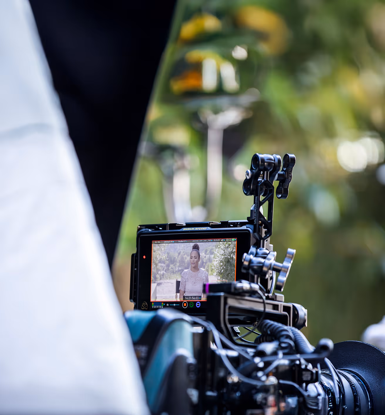 Camera monitor framing a woman during an outdoor video shoot
