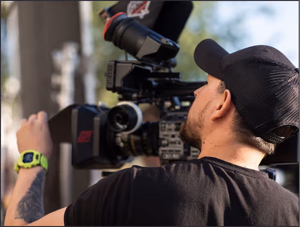 Camera operator filming with a shoulder-mounted camera rig