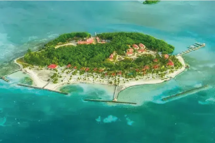 Aerial view of a small tropical island resort surrounded by turquoise water.