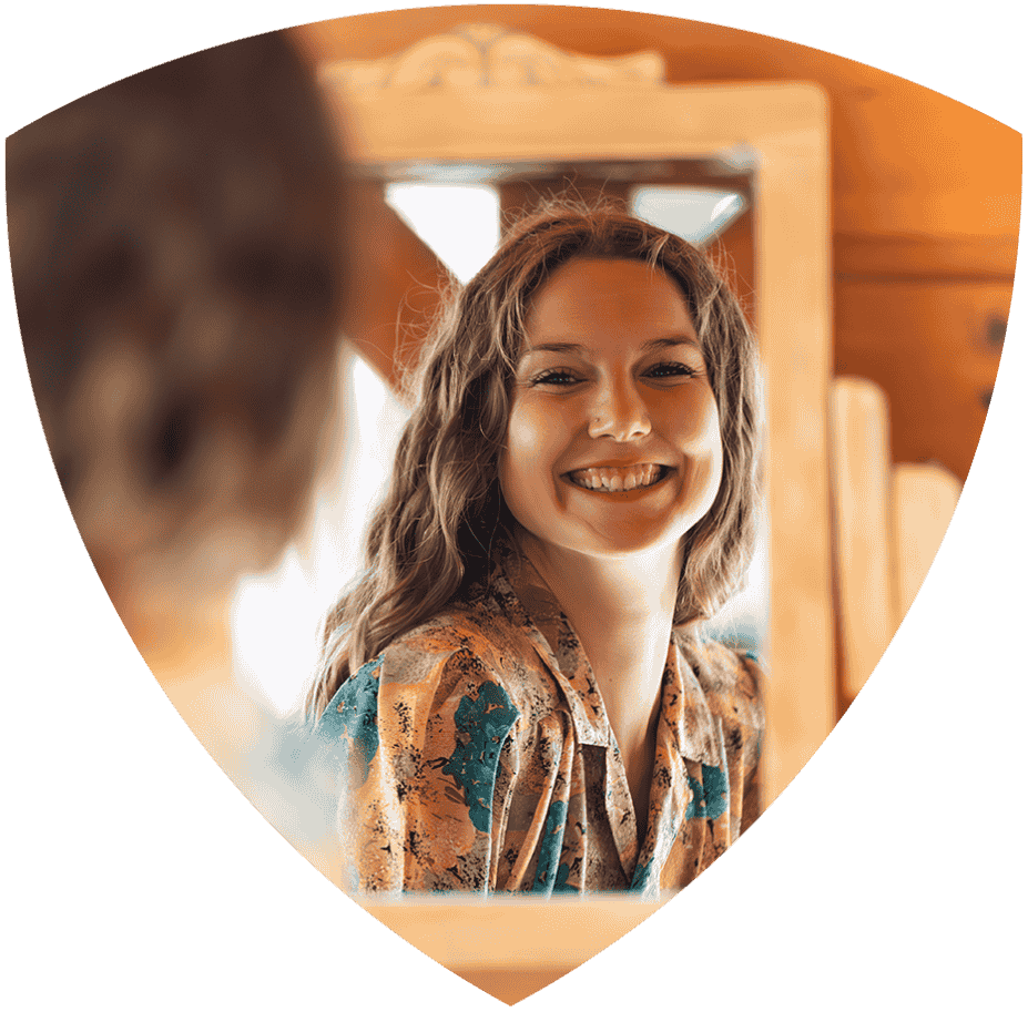 Smiling woman with wavy hair looking at her reflection