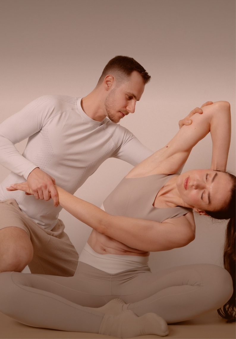 Assisted Stretch: Expert unterstützt eine Kundin bei der Seitdehnung