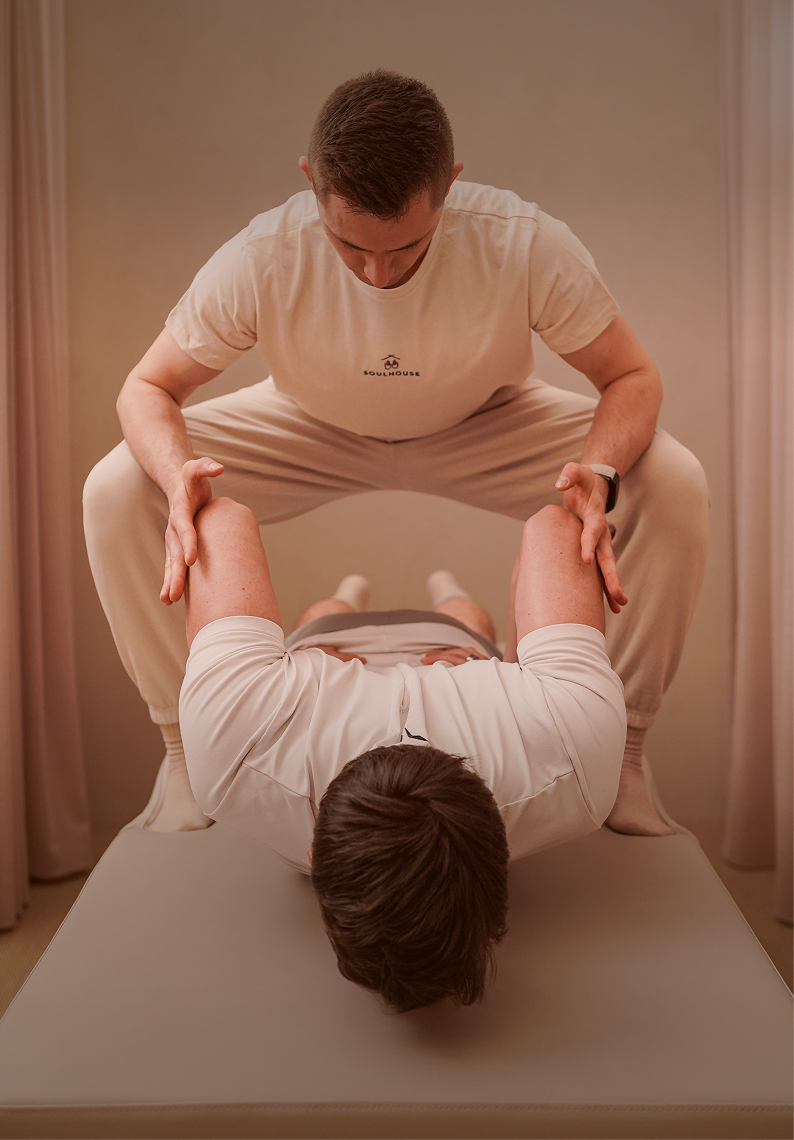 Assisted Stretch: Expert dehnt die Hüfte eines liegenden Kunden