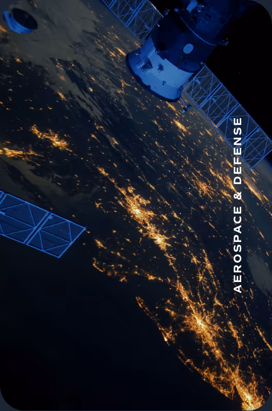 Satellite orbiting Earth at night with city lights visible below and text 'Aerospace & Defense'.