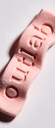 Bala de goma rosa torcida com a palavra 'outlab' em relevo.