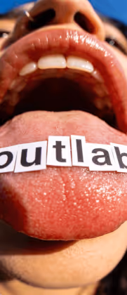 Língua para fora com letras coladas formando a palavra 'outlab' e boca aberta de uma pessoa.