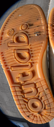 Sola de sapato laranja de borracha com a marca Outddo gravada.