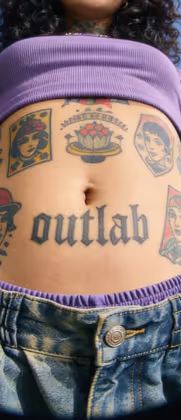Barriga tatuada com a palavra outlab e várias tatuagens coloridas ao redor do umbigo.