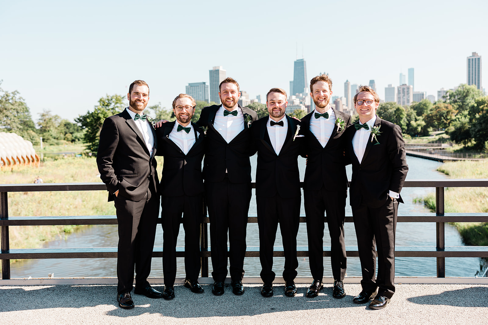 Dylan and five friends dressed in tuxedos at a wedding, with the Chicago skyline behind them.