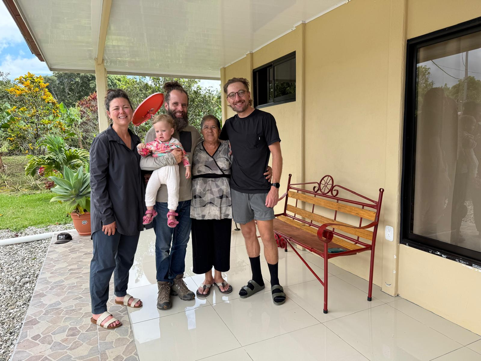 Dylan with a group of people and a child on a covered patio.