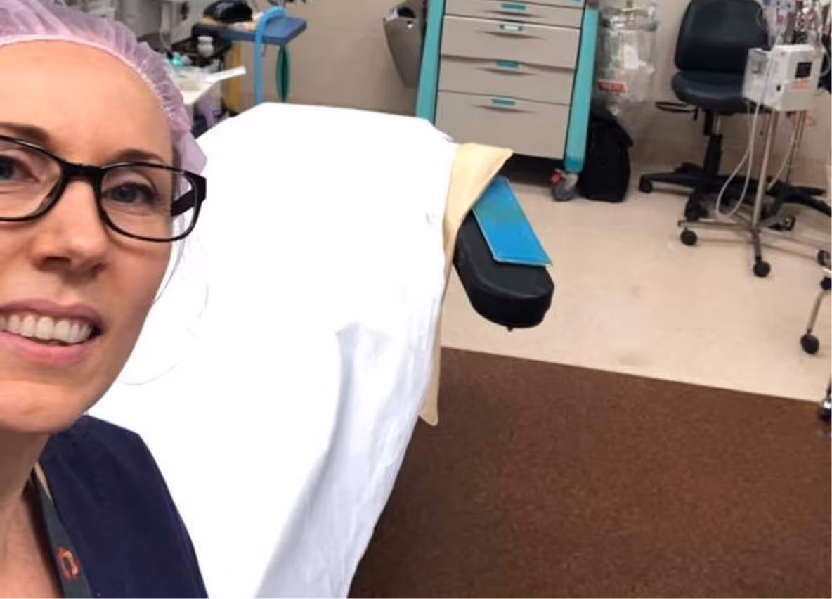 Joanna in her nursing scrubs in a hospital room