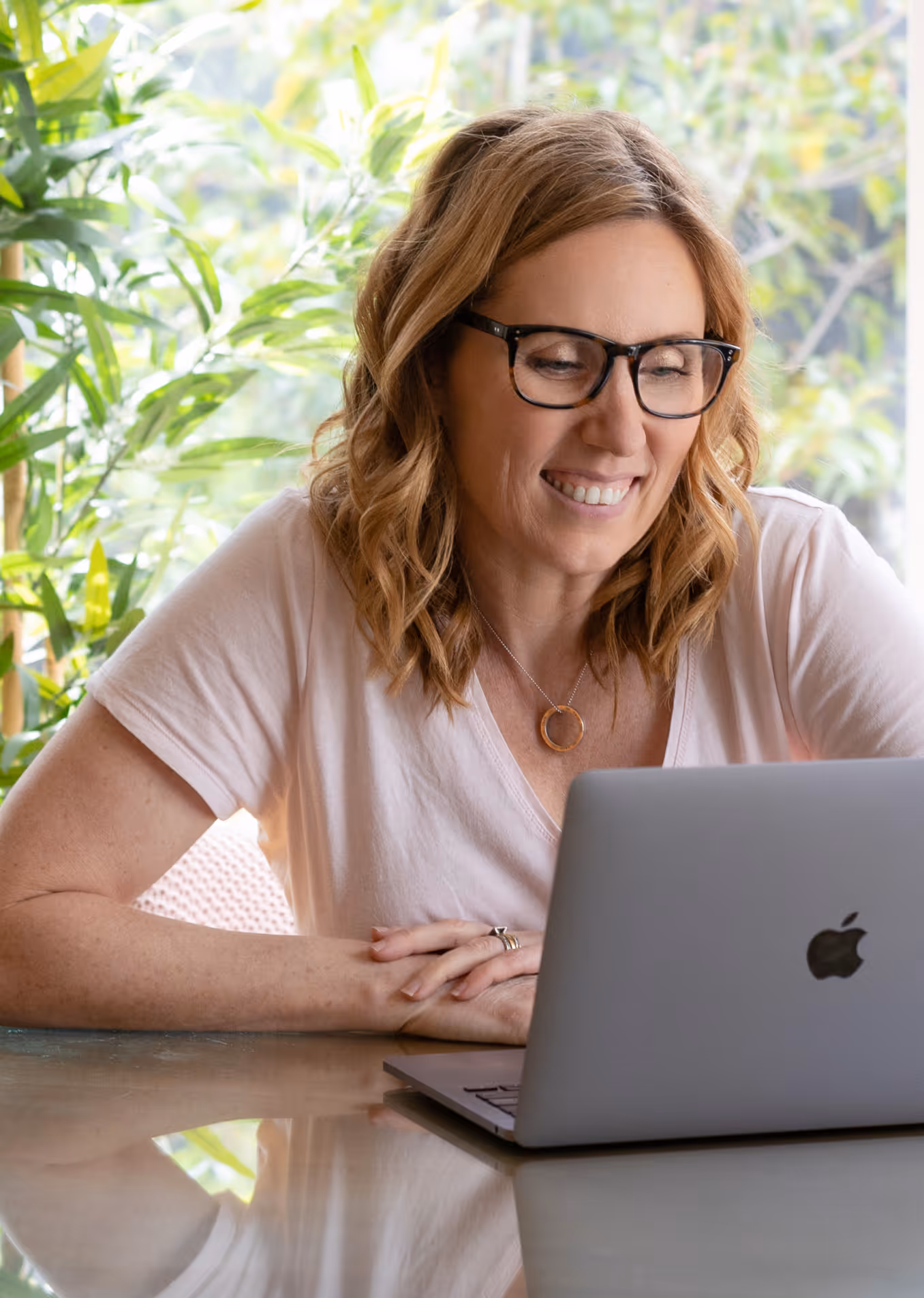 Joanna smiling while using her laptop