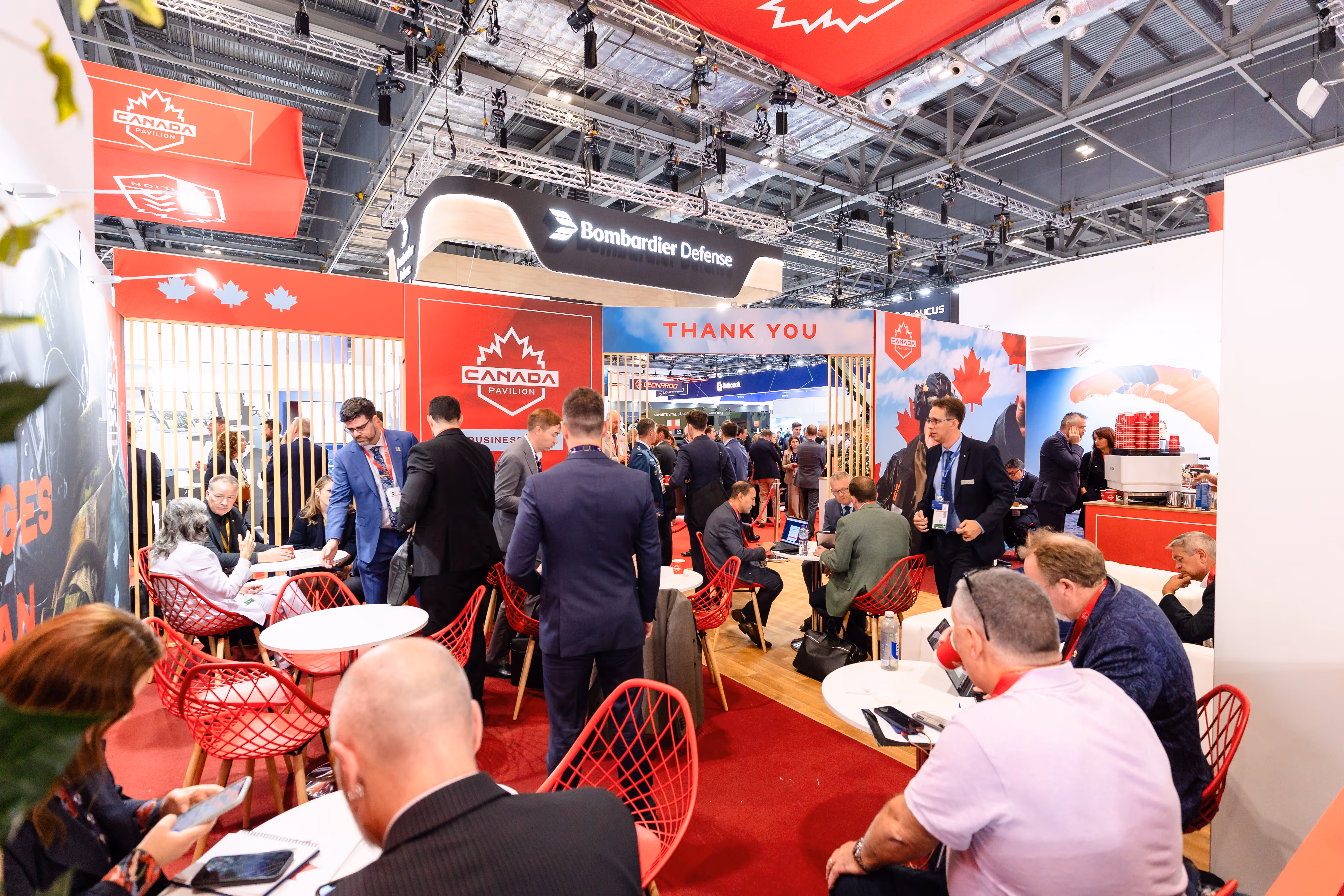 Busy CANSEC trade show floor with defence industry professionals networking among exhibition booths.