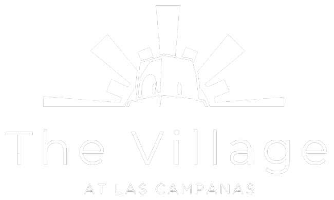 Logo of The Village at Las Campanas featuring a stylized building with radiating lines above the text.