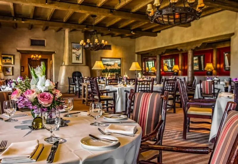 Adobe-style southwestern home with terracotta stucco walls, wooden beams, desert landscaping, and a two-car garage.