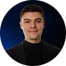 Portrait d'un jeune homme souriant portant un pull noir et un blazer noir sur un fond sombre avec un halo bleu.