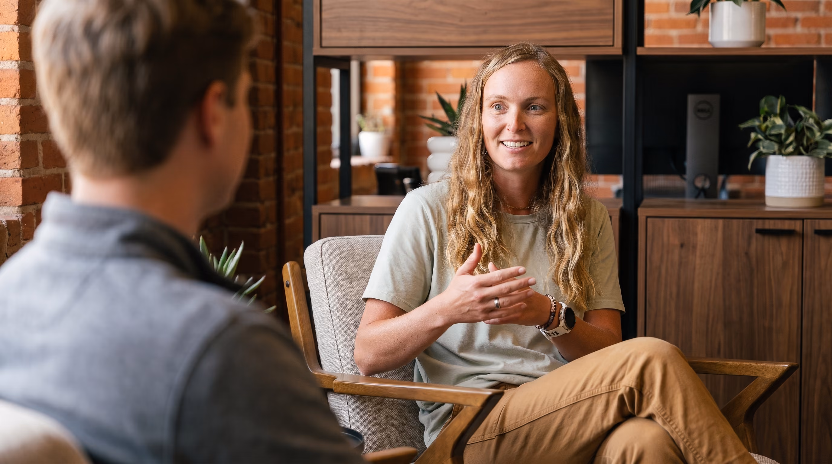 Stephanie, a KEPM asset transfer specialist, talking with a client in a brick-walled office